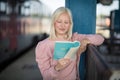 Young lady reading book, waiting for a train Royalty Free Stock Photo