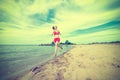 Young lady running at the sunny summer sand beach Royalty Free Stock Photo