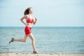 Young lady running at the sunny summer sand beach Royalty Free Stock Photo
