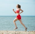 Young lady running at the sunny summer sand beach Royalty Free Stock Photo