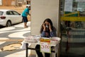 A young lady selling protective face mask outside a shopping center