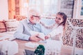 Young lady showing grandfather how taking picture at phone