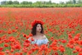 Young lady sitiing in poppies