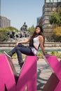 Young lady sitting on the CDMX sculpture in la Condesa