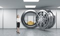 Young lady standing in front of a big unlocked round metal safe