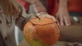 A young lady is starting to carve a pumpkin for Halloween