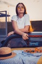 Young lady in sunglasses, white t-shirt is posing in yellow car cabriolet with pizza, striped cloth and hat on its trunk Royalty Free Stock Photo