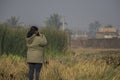 A young lady taking picture of beautiful landscape of a wetland and lake near Kolkata