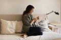 Young lady tuck her legs on sofa relax using smartphone Royalty Free Stock Photo