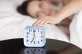 Young lady turning off ringing alarm clock in the morning Royalty Free Stock Photo
