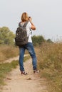 Young lady walking on a rural road with digital camera Royalty Free Stock Photo