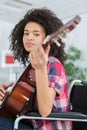 young lady in wheelchair playing guitar Royalty Free Stock Photo