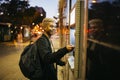 Young man at a bank cashier on street