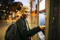 Young man at a bank cashier on street