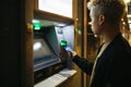 Young man at a bank cashier on street