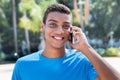 Young latin american man laughing at phone outdoor Royalty Free Stock Photo