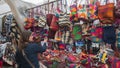 Young Latin American woman comparing Shigras that hang for sale in the Plaza de los Ponchos in the city of Otavalo Royalty Free Stock Photo