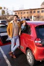 Latin or arab man leaned over near car with opened door on parking slot of city