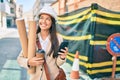 Young latin architect girl holding blueprints and using smartphone at the city Royalty Free Stock Photo