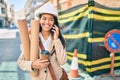 Young latin architect girl holding blueprints and using smartphone at the city Royalty Free Stock Photo