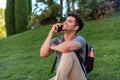 Young latin man sitting in the grass talking by mobile phone. Royalty Free Stock Photo