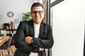 Young latin businessman smiling happy standing with arms crossed gesture at the office Royalty Free Stock Photo