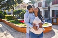 Young latin couple expecting baby hugging each other and kissing at park Royalty Free Stock Photo