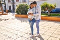 Young latin couple expecting baby hugging each other and kissing at park Royalty Free Stock Photo