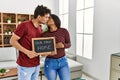 Young latin couple kissing and holding our first home blackboard at house Royalty Free Stock Photo