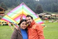 Young Latin couple of man and woman walk in the park sharing quality time playing frisbee and flying a kite outdoors doing sports Royalty Free Stock Photo