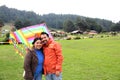 Young Latin couple of man and woman walk in the park sharing quality time playing frisbee and flying a kite outdoors doing sports Royalty Free Stock Photo