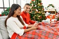 Young latin couple playing video game sitting on the sofa at home Royalty Free Stock Photo