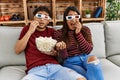 Young latin couple scared watching movie using 3d glasses at home Royalty Free Stock Photo