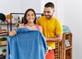 Young latin couple smiling happy choosing clothes at clothing store