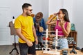 Young latin couple smiling happy choosing sunglasses at clothing store