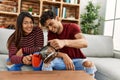 Young latin couple smiling happy drinking coffee sitting on the sofa at home Royalty Free Stock Photo