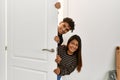 Young latin couple smiling happy getting in at new home