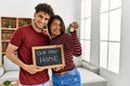 Young latin couple smiling happy holding our first home blackboard and key at house Royalty Free Stock Photo