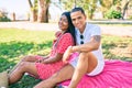 Young latin couple smiling happy and hugging sitting on the grass at the park Royalty Free Stock Photo