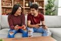 Young latin couple smiling happy playing video game sitting on the sofa at home Royalty Free Stock Photo