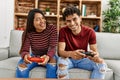 Young latin couple smiling happy playing video game sitting on the sofa at home Royalty Free Stock Photo