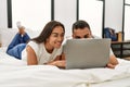 Young latin couple smiling happy using laptop lying on the bed Royalty Free Stock Photo