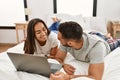 Young latin couple smiling happy using laptop lying on the bed Royalty Free Stock Photo