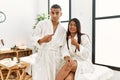 Young latin couple wearing towel standing at beauty center pointing aside worried and nervous with forefinger, concerned and