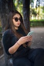 Young latin female at the woods, making a selfie. Young latin woman in the park with your cell phone Royalty Free Stock Photo