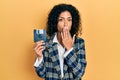 Young latin girl holding floppy disk covering mouth with hand, shocked and afraid for mistake Royalty Free Stock Photo