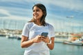Young latin girl smiling happy using smartphone at the beach Royalty Free Stock Photo