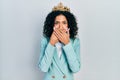 Young latin girl wearing business clothes and queen crown shocked covering mouth with hands for mistake Royalty Free Stock Photo