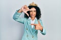 Young latin girl wearing business clothes and queen crown smiling making frame with hands and fingers with happy face Royalty Free Stock Photo