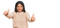 Young latin girl wearing wool winter sweater approving doing positive gesture with hand, thumbs up smiling and happy for success Royalty Free Stock Photo